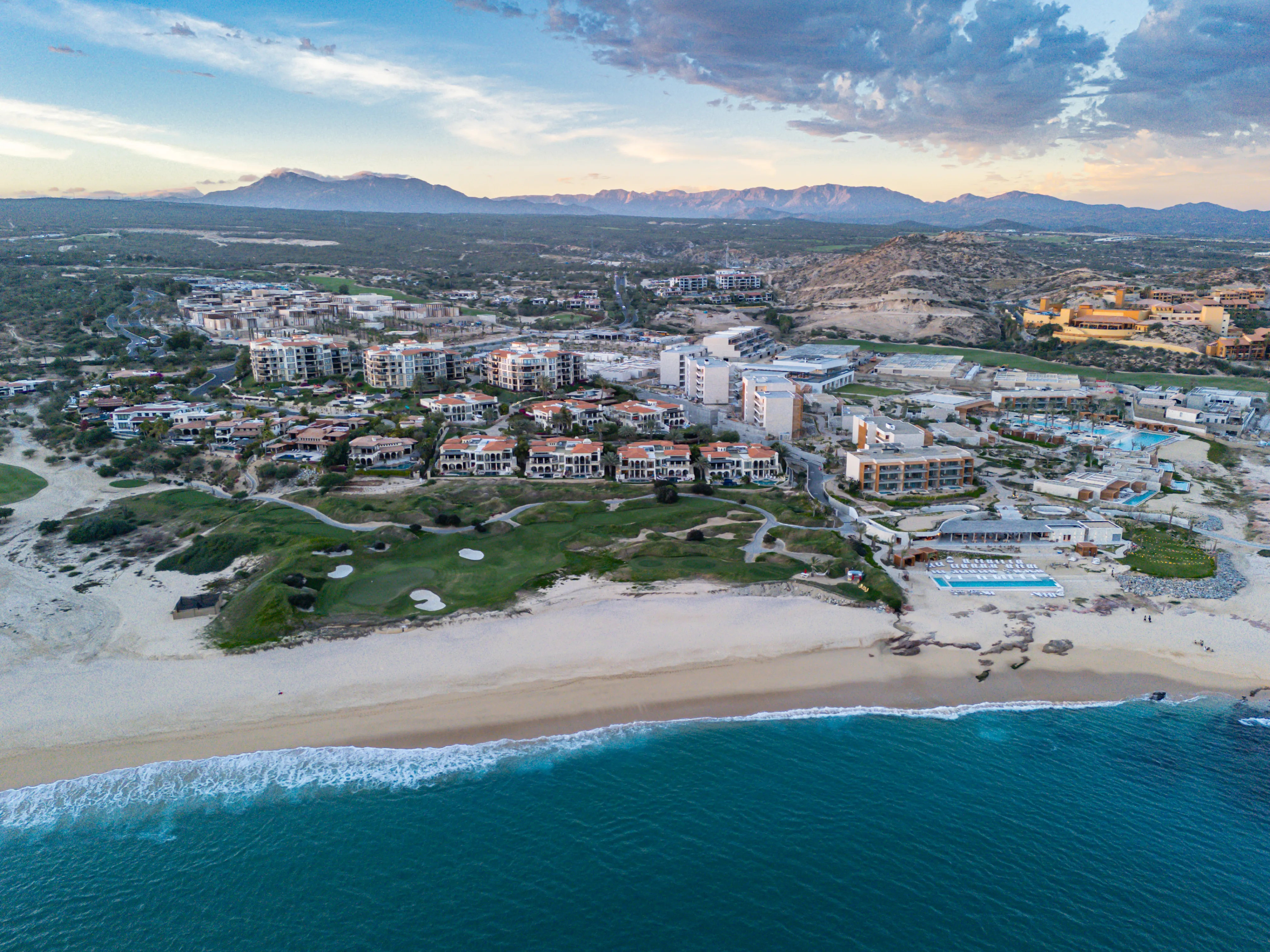 Breathtaking high-angle aerial view of the ultra-luxury Cabo del Sol master-planned community and the deep blue ocean corridor.