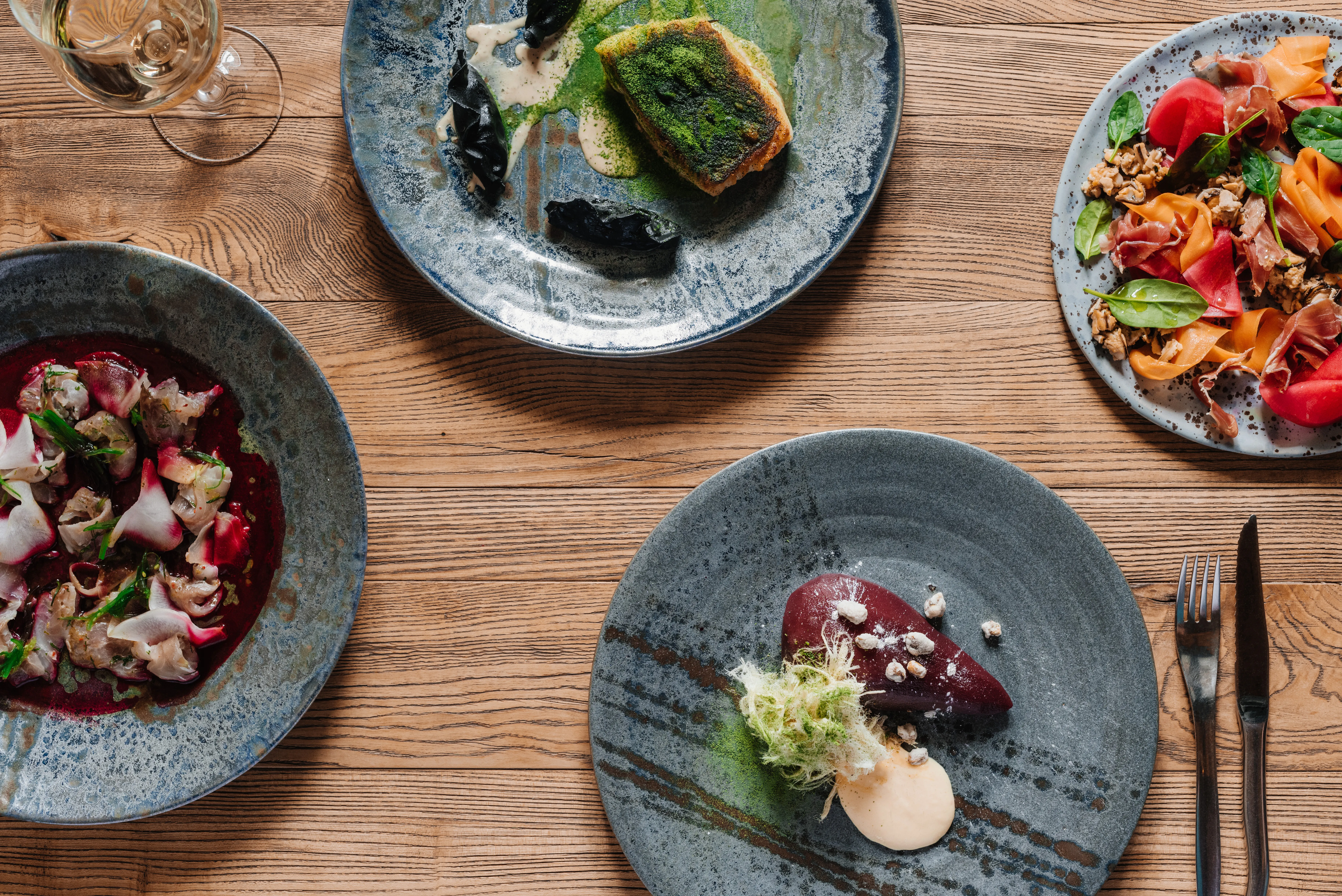 Flat lay top view of exquisite gourmet dishes and a glass of white wine at a luxury resort restaurant within the Diamante community in Cabo San Lucas.