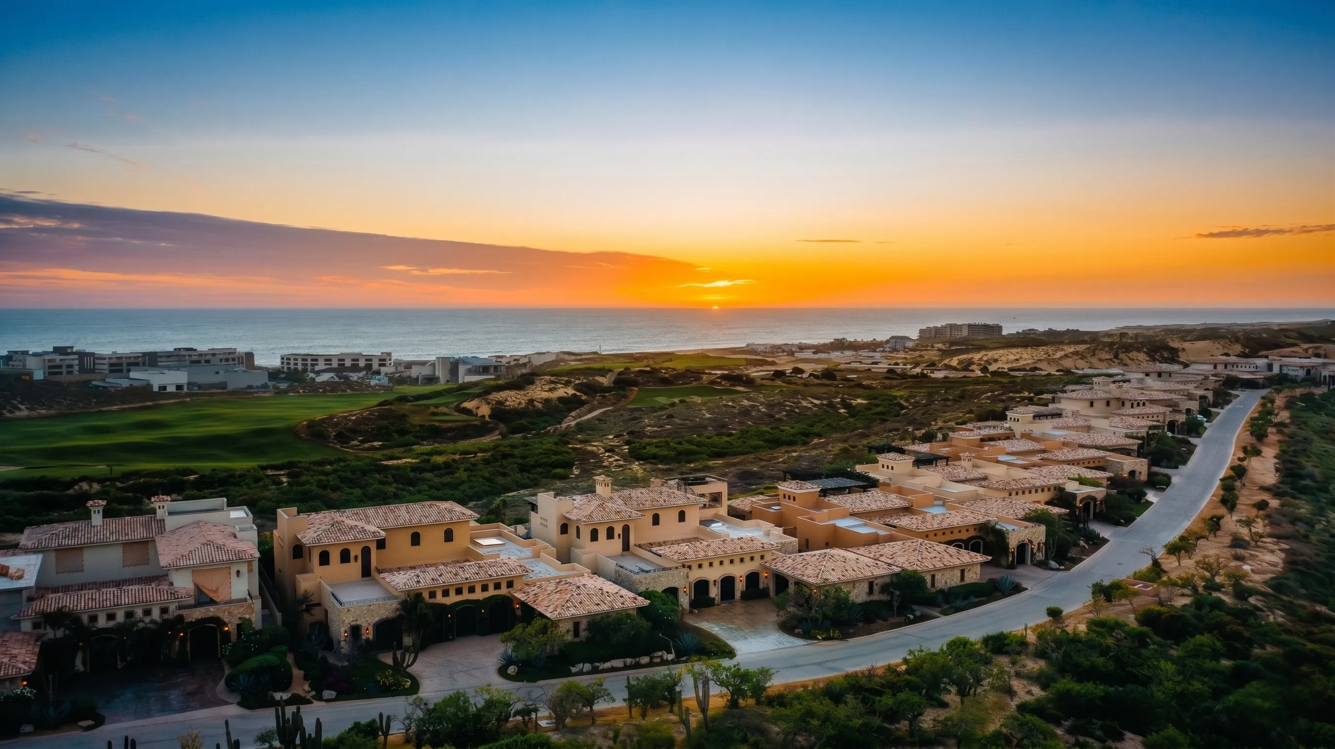 Aerial golden hour view of upscale residential enclaves and luxury oceanview properties facing the Pacific sunset within Diamante Cabo San Lucas.