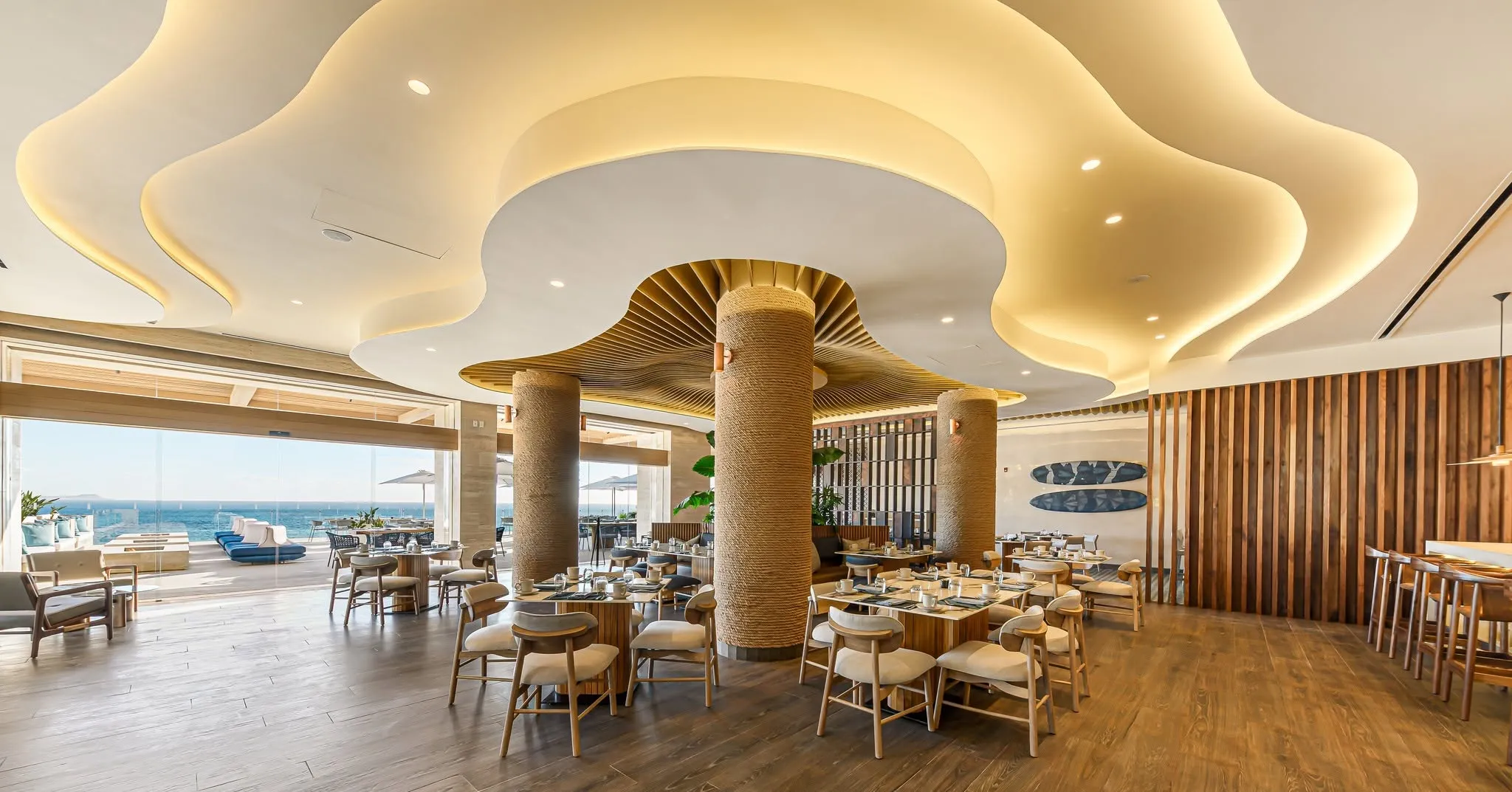 The exclusive private Beach Club at Querencia Los Cabos, showcasing a luxury infinity pool, beachfront cabanas, and premium outdoor dining spaces next to the surf.