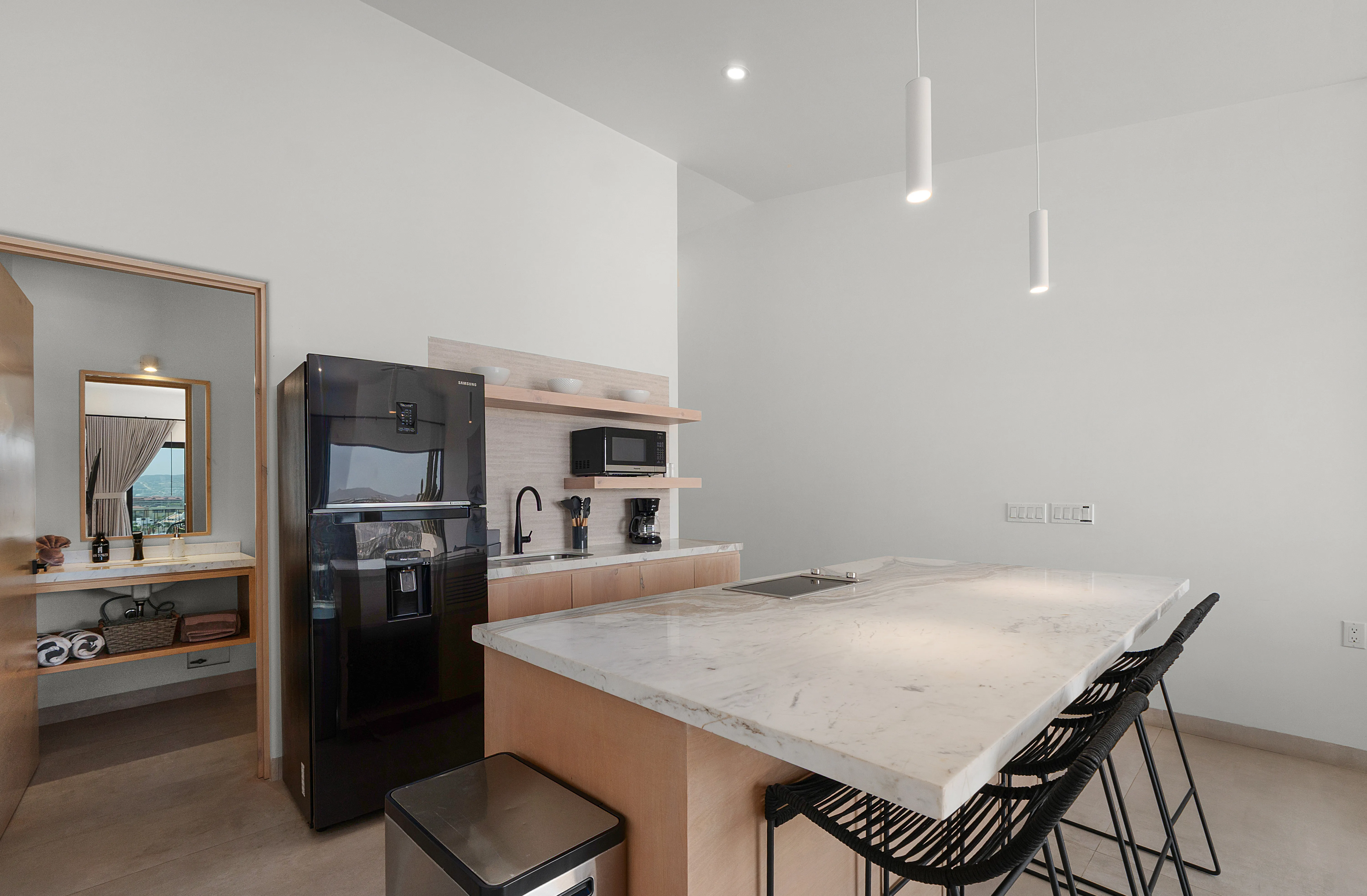 Gourmet condominium kitchen with high-end marble countertops, built-in modern appliances, and designer pendant lighting.