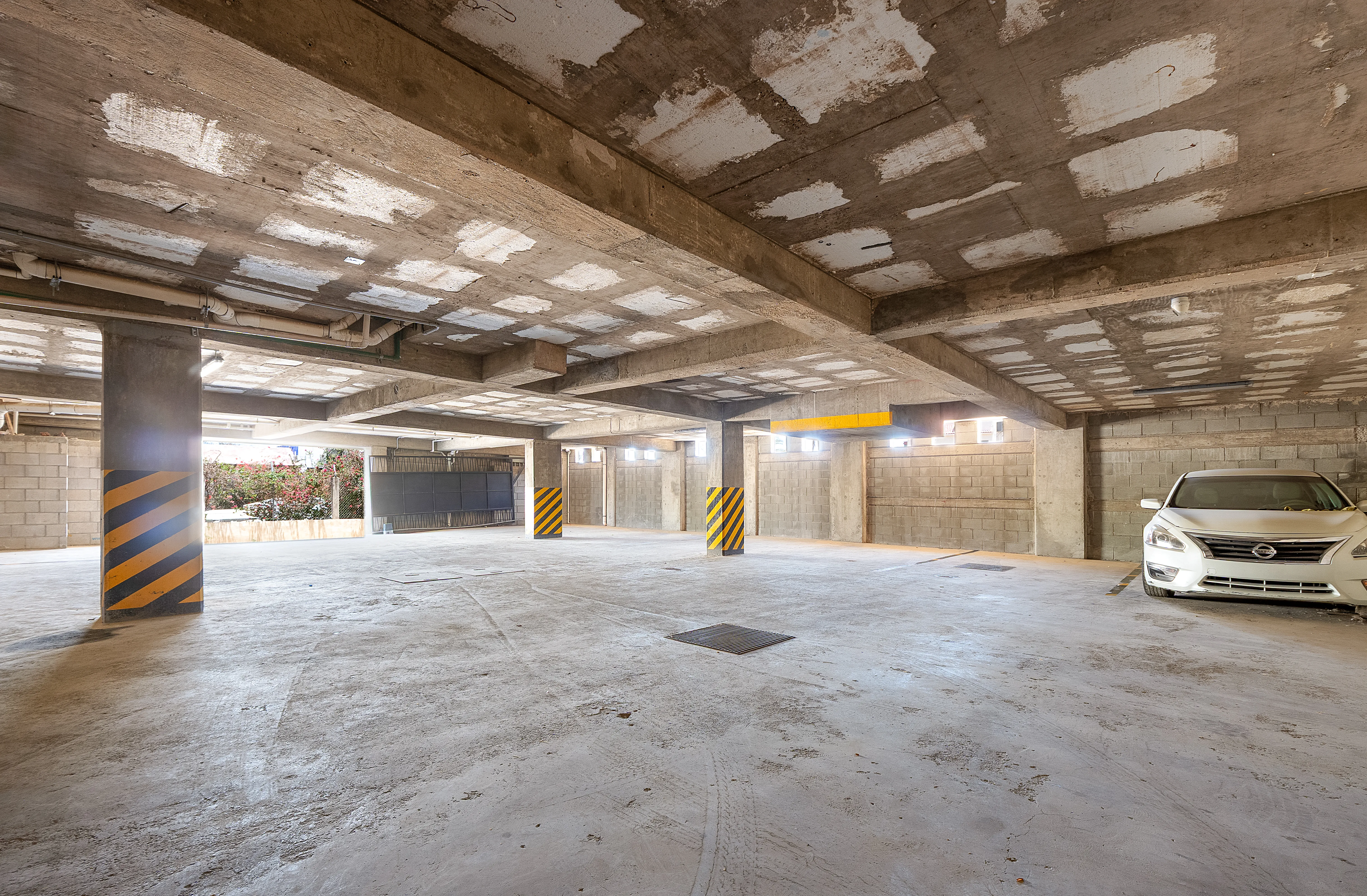 Secure and well-lit covered parking garage area with designated resident vehicle parking spaces at 605 Tower.