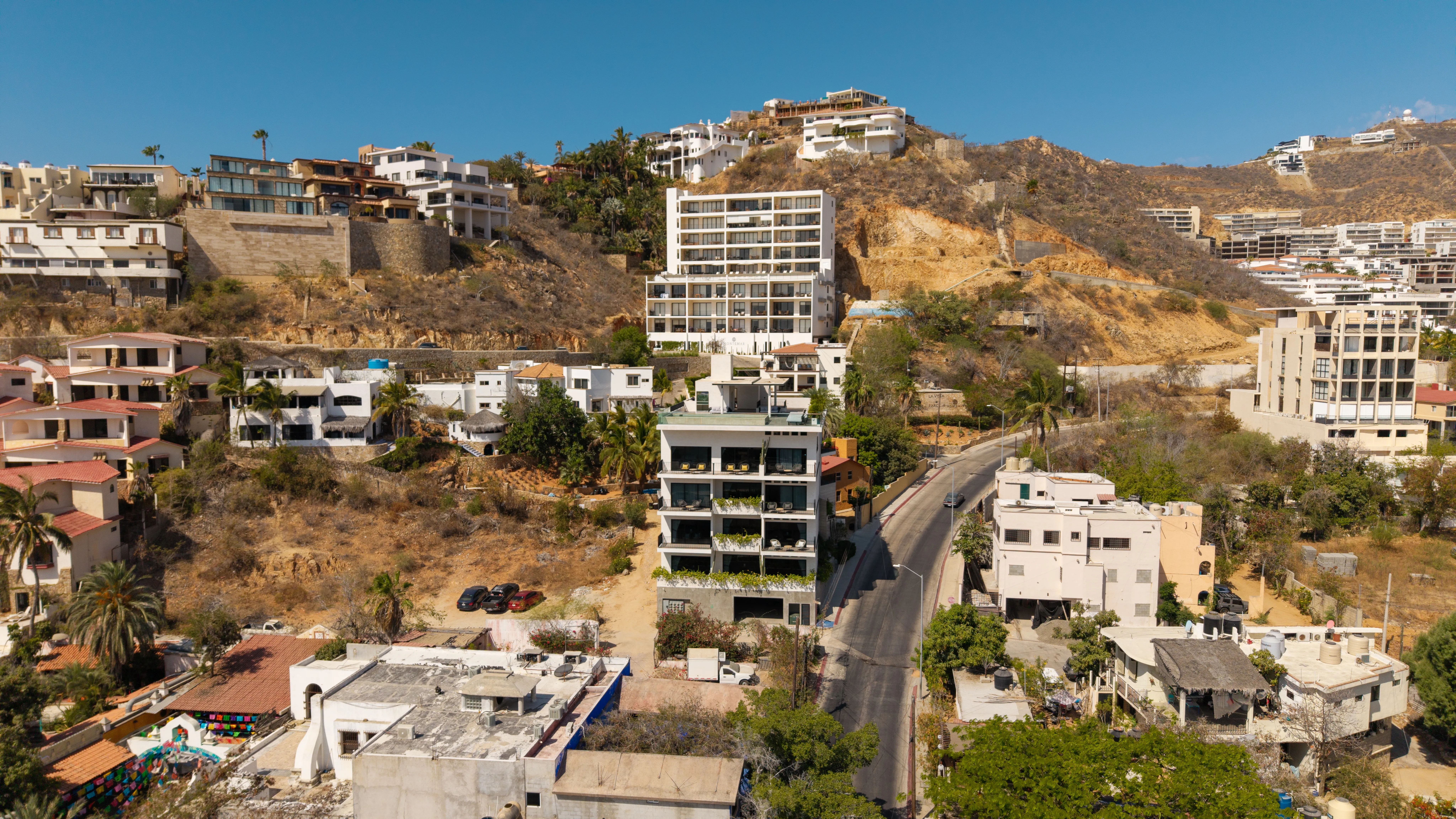 Sleek architectural exterior view of the 605 Tower modern mid-rise condominium development against a mountain backdrop.