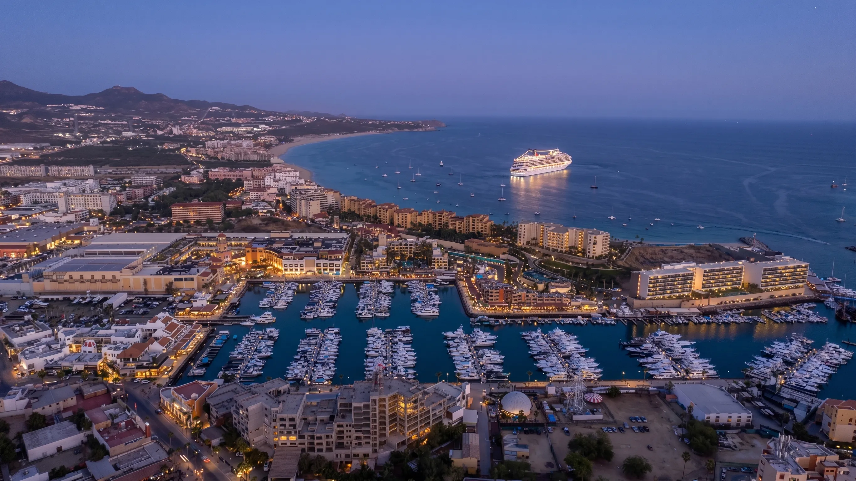 Breathtaking blue hour perspective overlooking the Cabo San Lucas marina yacht harbor, Medano Beach, and the Pacific Ocean from 605 Tower.