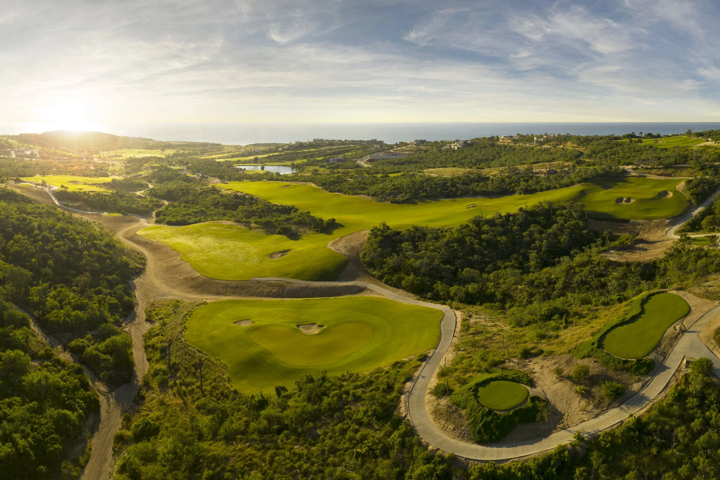 Scenic sunset view over the rolling greens of the dual-signature golf course in Puerto Los Cabos with ocean horizons. Scenic sunset view over the rolling greens of the dual-signature golf course in Puerto Los Cabos with ocean horizons.