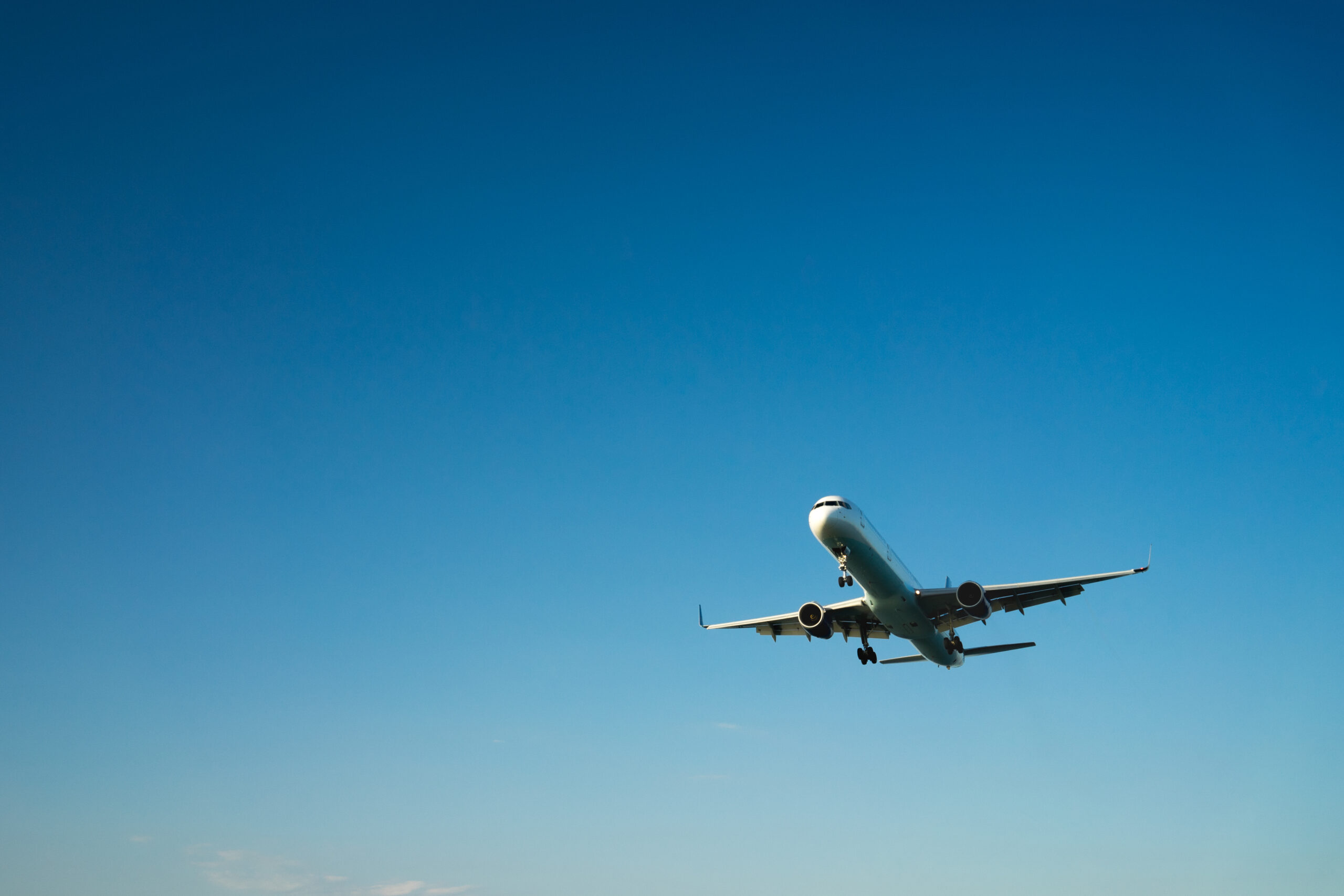 Airplane arriving under blue sky