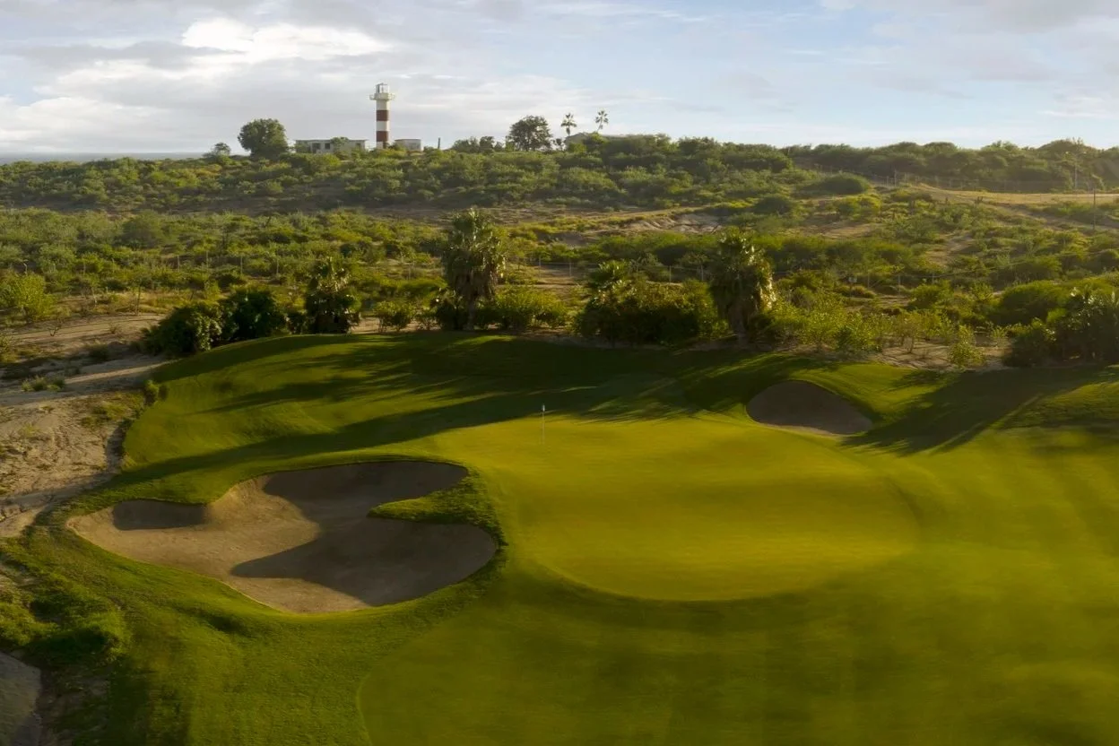 Scenic view of the iconic lighthouse from the Jack Nicklaus golf course at Puerto Los Cabos during golden hour.